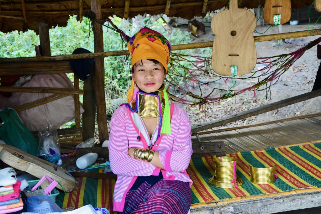 Kayan woman sitting on a colorful mat