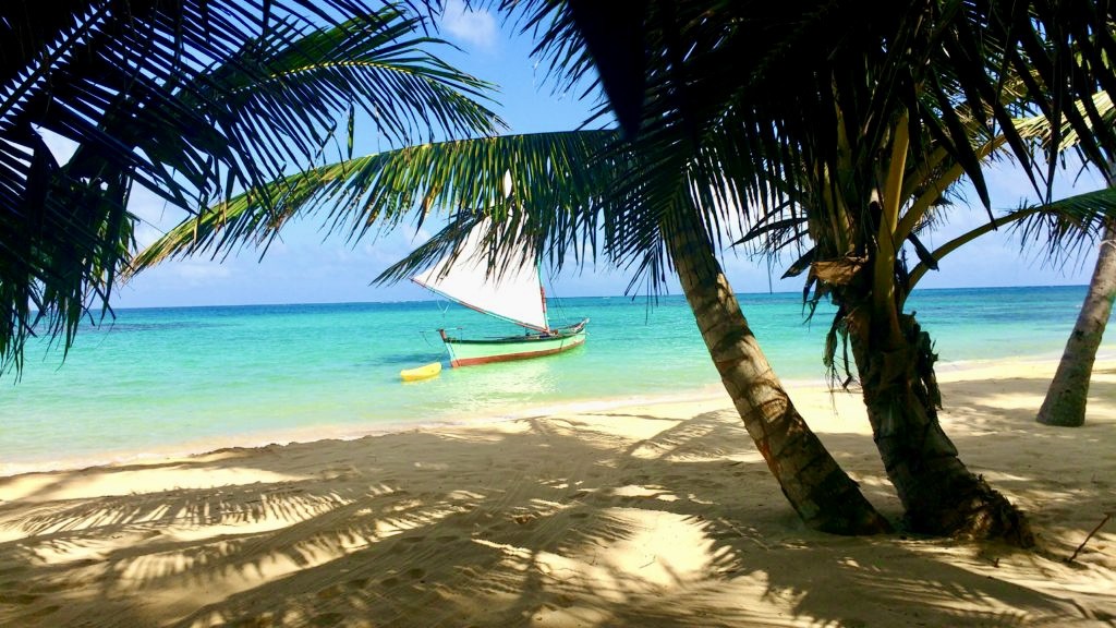 Little green boat on a Little Corn beach