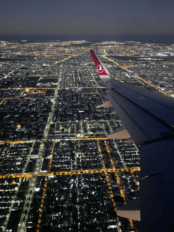 wings of plane over a city