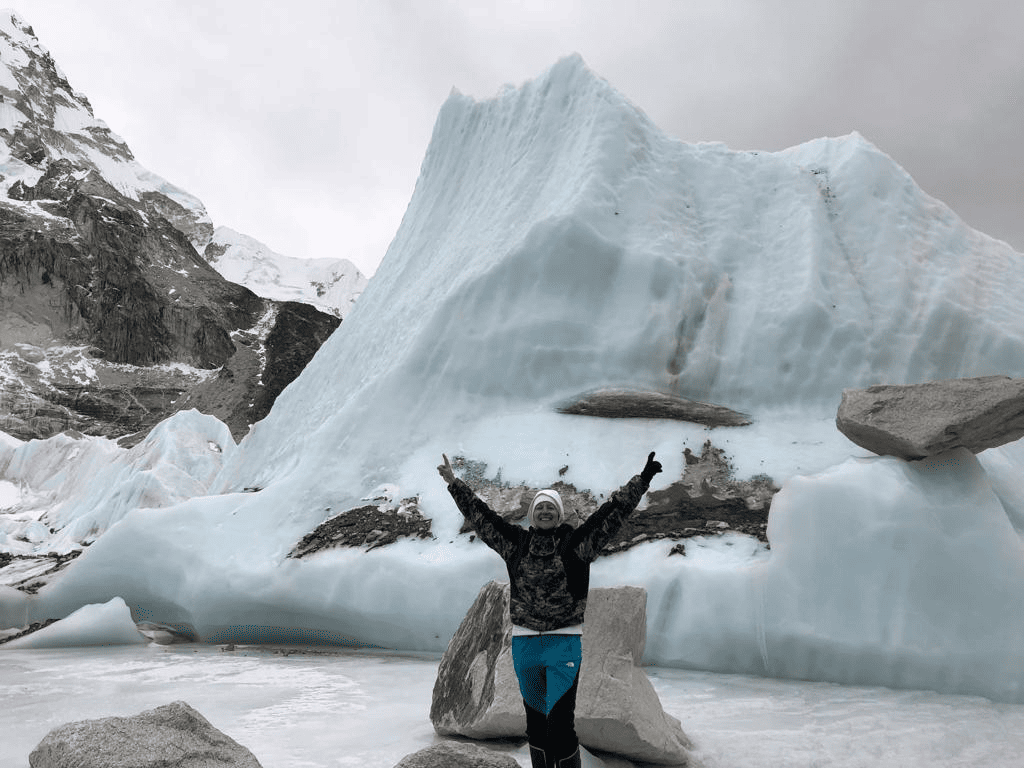 women traveler waving hands in front of an iceburg